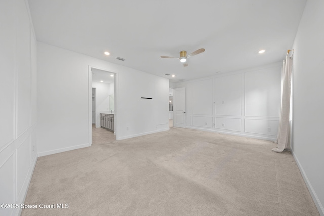 empty room featuring ceiling fan and light colored carpet