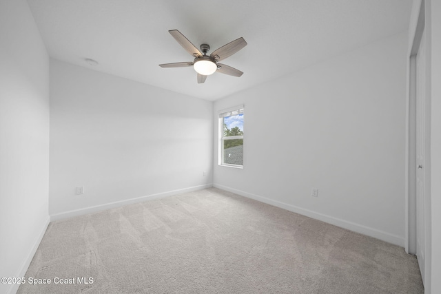 carpeted spare room with ceiling fan