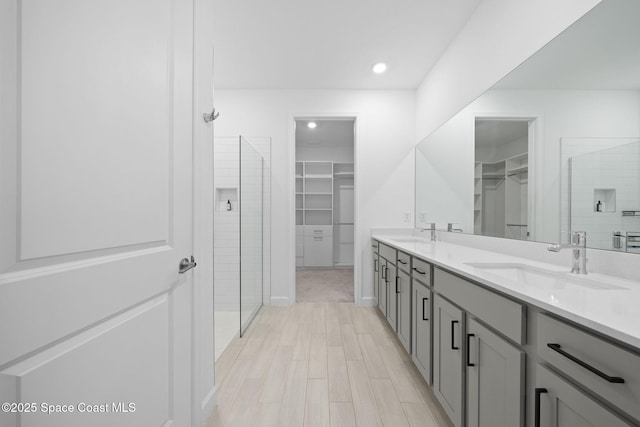 bathroom featuring vanity, hardwood / wood-style flooring, and tiled shower