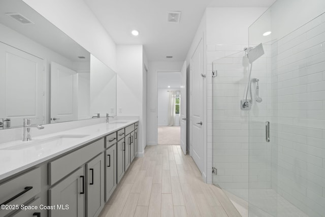 bathroom with wood-type flooring, an enclosed shower, and vanity