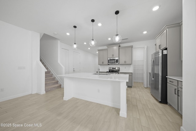 kitchen featuring decorative light fixtures, sink, appliances with stainless steel finishes, and gray cabinets