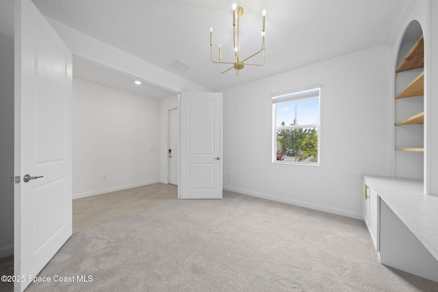 unfurnished room featuring light colored carpet and an inviting chandelier