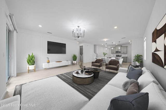 living room with an inviting chandelier and light hardwood / wood-style flooring