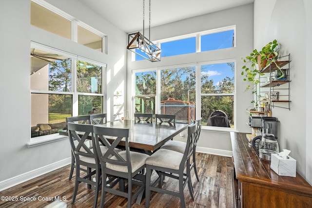 dining space with a chandelier and dark wood-type flooring