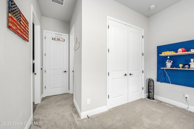 interior space with a closet and light colored carpet