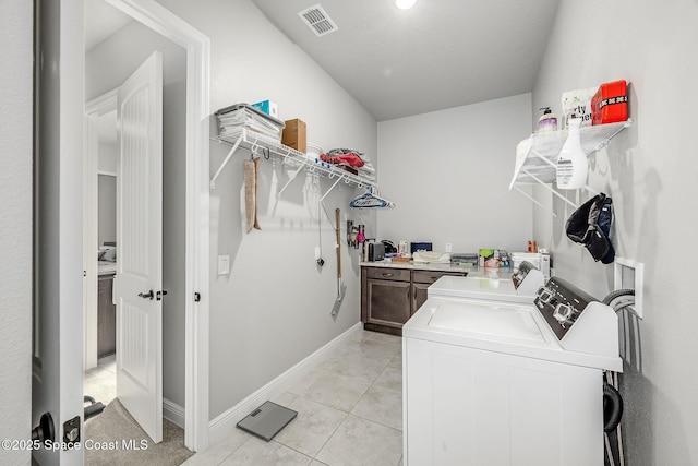 clothes washing area with light tile patterned floors and separate washer and dryer