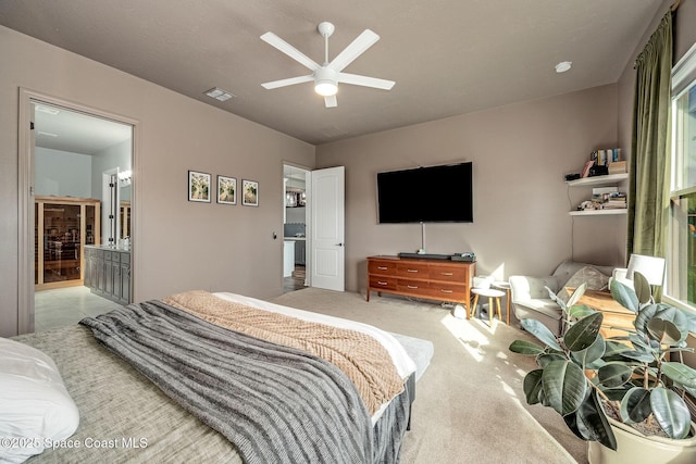 carpeted bedroom featuring connected bathroom and ceiling fan