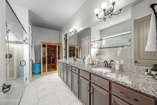 bathroom featuring a chandelier, vanity, an enclosed shower, and tile patterned flooring