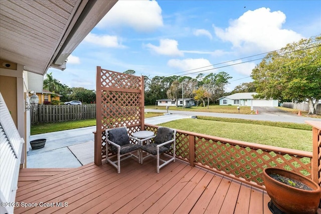 wooden terrace featuring a lawn