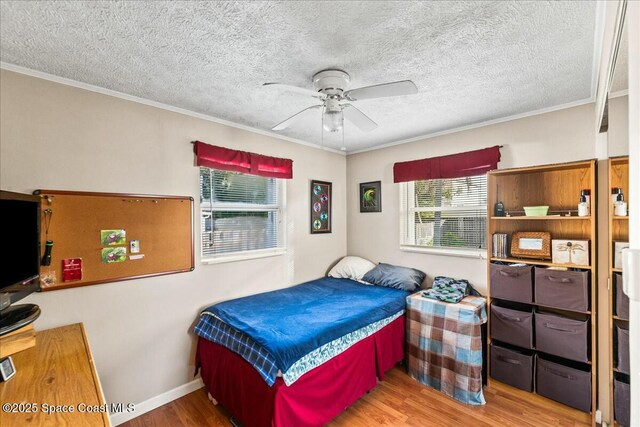 bedroom featuring ceiling fan, crown molding, and multiple windows