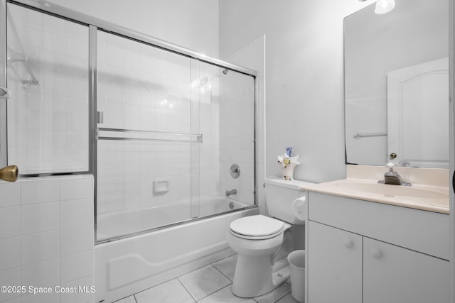 full bathroom featuring combined bath / shower with glass door, vanity, tile patterned flooring, and toilet