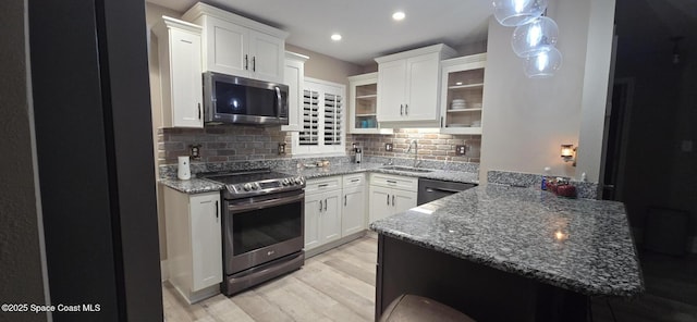 kitchen with white cabinets, stainless steel appliances, tasteful backsplash, and sink