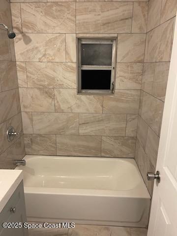 bathroom featuring vanity and tiled shower / bath