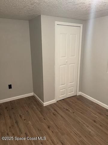 empty room featuring dark hardwood / wood-style floors and a textured ceiling