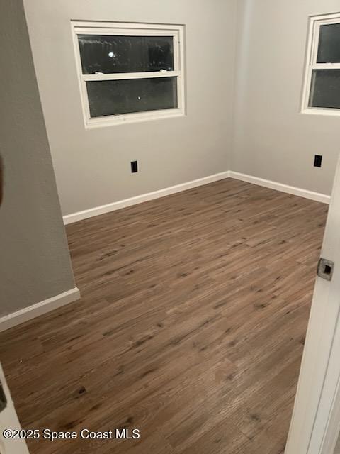 unfurnished room with dark hardwood / wood-style flooring