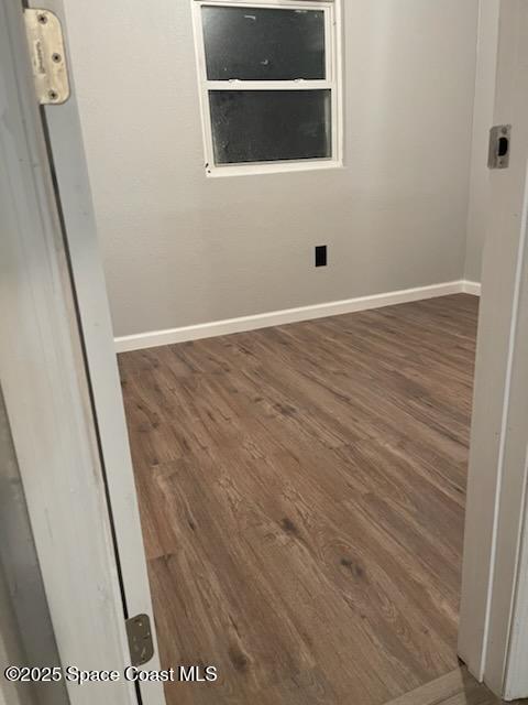 empty room with dark hardwood / wood-style flooring