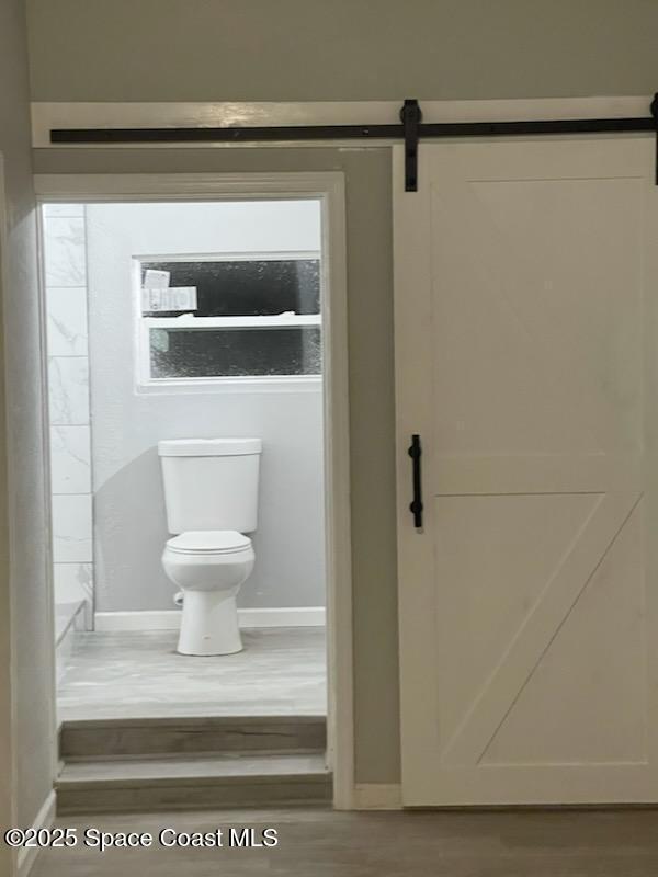 bathroom featuring hardwood / wood-style flooring and toilet