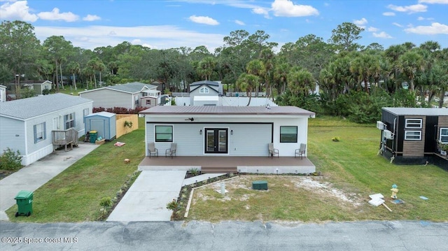 view of front of house featuring a storage unit, a porch, and a front yard