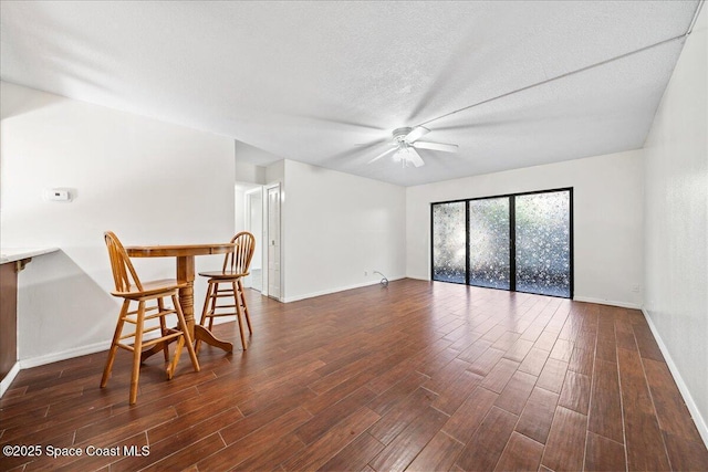 interior space featuring dark hardwood / wood-style floors, ceiling fan, and a textured ceiling