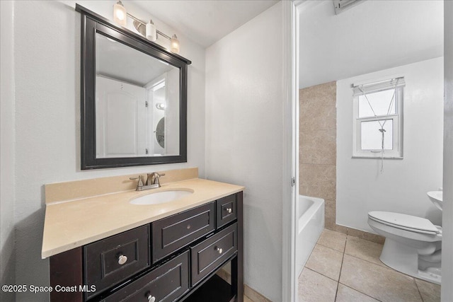 bathroom featuring tile patterned floors, a tub to relax in, vanity, and toilet