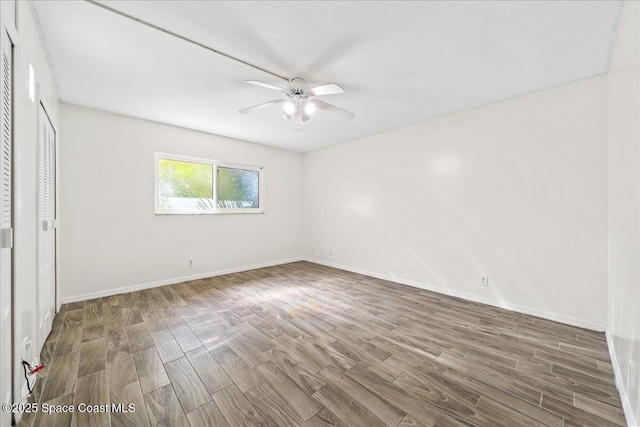 unfurnished bedroom featuring ceiling fan, dark hardwood / wood-style flooring, and a closet