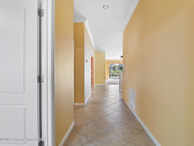 hall with light tile patterned flooring and crown molding