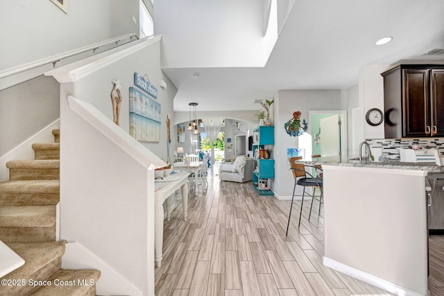 staircase with hardwood / wood-style floors and sink