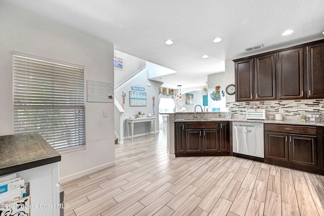 kitchen featuring tasteful backsplash, sink, kitchen peninsula, stainless steel dishwasher, and dark brown cabinets