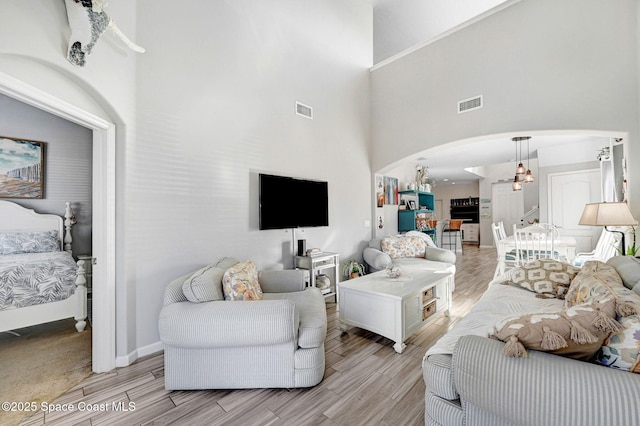 living room featuring a towering ceiling and a chandelier