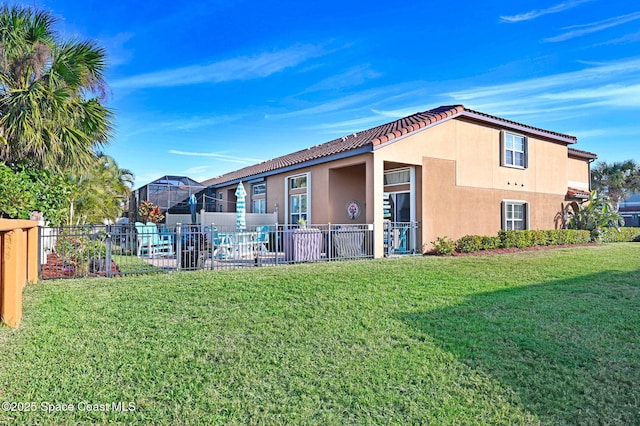 back of property with a yard and glass enclosure