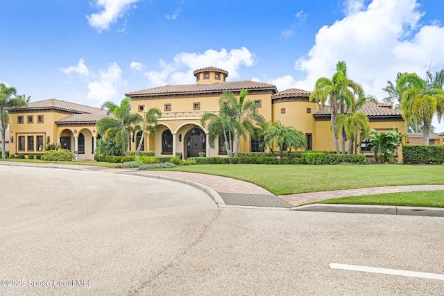 mediterranean / spanish home featuring a front yard