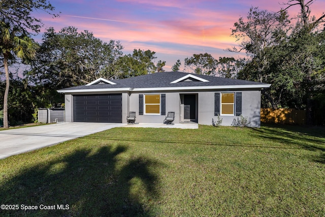 ranch-style house with a garage and a lawn