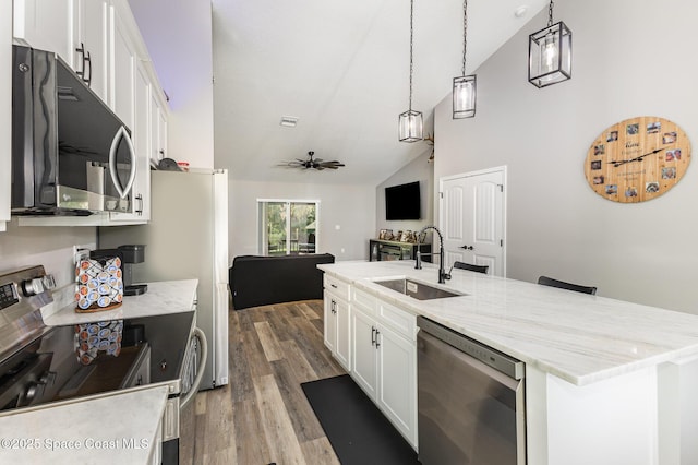 kitchen featuring appliances with stainless steel finishes, ceiling fan, sink, white cabinets, and hanging light fixtures