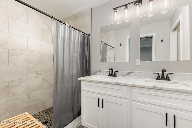 bathroom with vanity, a textured ceiling, and curtained shower