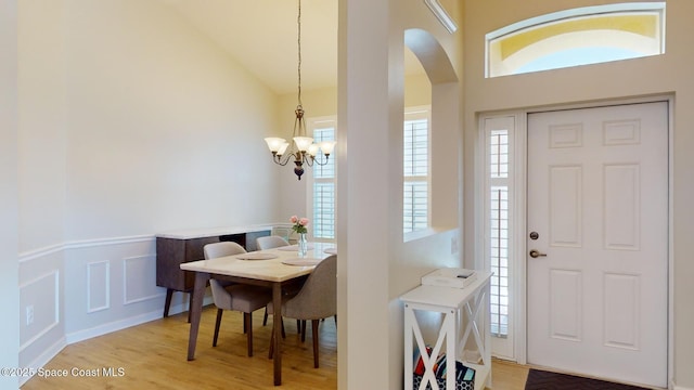 foyer featuring vaulted ceiling, light hardwood / wood-style flooring, and an inviting chandelier