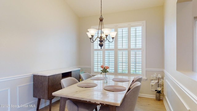 dining room featuring a chandelier, a healthy amount of sunlight, and light hardwood / wood-style floors