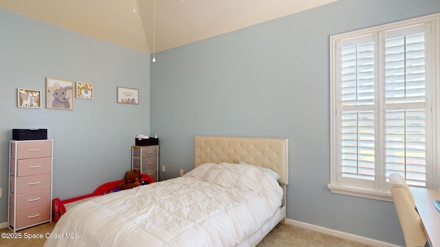 carpeted bedroom with lofted ceiling