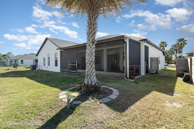 back of house with a sunroom and a lawn