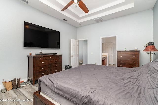 bedroom with ensuite bathroom, ceiling fan, and light hardwood / wood-style floors