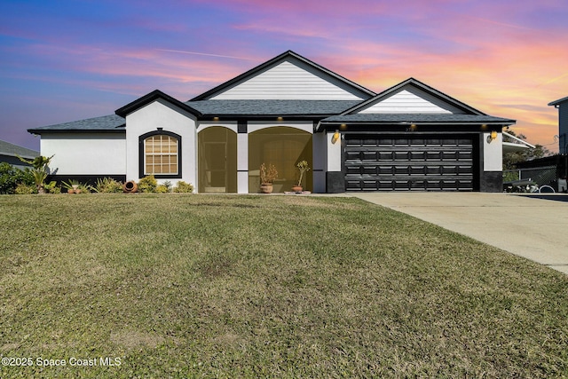 view of front of home with a yard and a garage