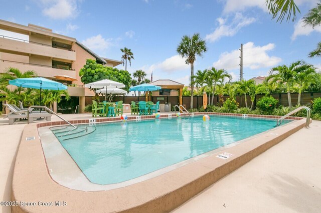 community pool with a gazebo, a patio, and fence