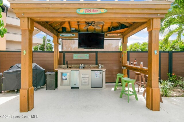 view of patio with a gazebo, grilling area, ceiling fan, and exterior bar