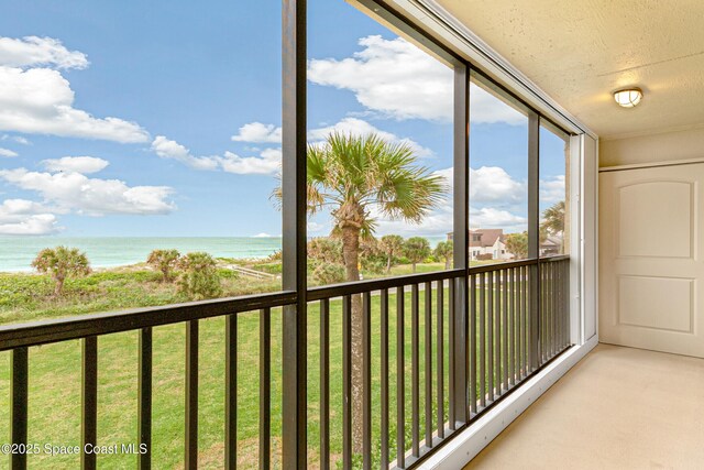 unfurnished sunroom featuring a water view