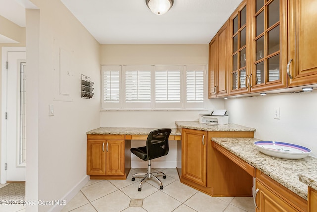 office space with light tile patterned flooring and built in desk