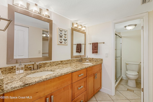 bathroom featuring vanity, tile patterned floors, toilet, a textured ceiling, and a shower with shower door