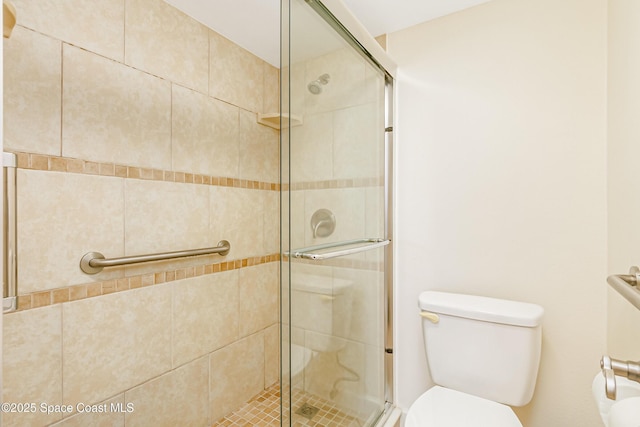 bathroom with toilet and an enclosed shower