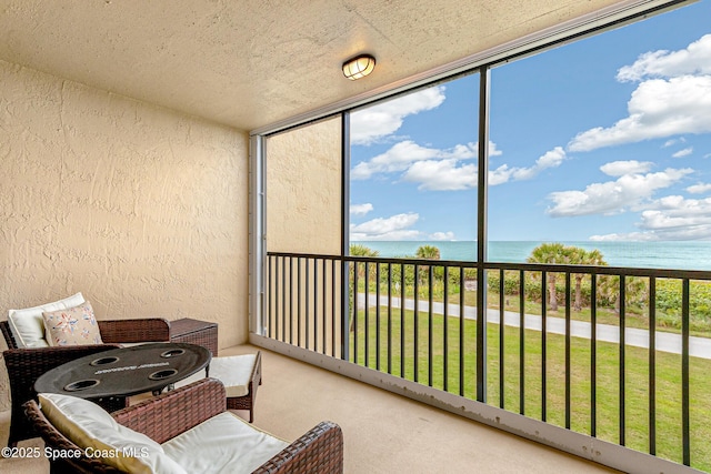 sunroom featuring a water view