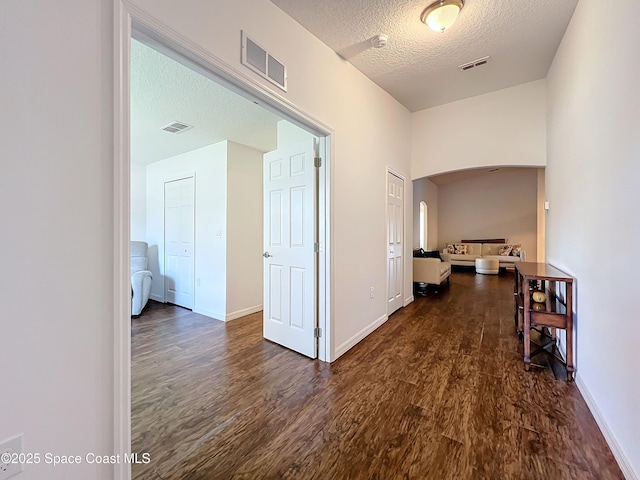 hallway featuring a textured ceiling and dark wood-type flooring