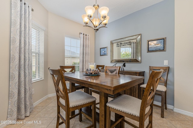 dining space featuring light tile patterned floors and an inviting chandelier