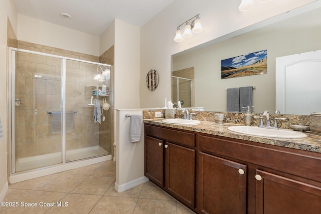 bathroom featuring tile patterned flooring, vanity, and a shower with door